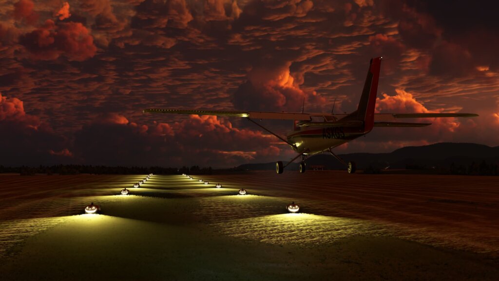 A Cessna 172 comes into land on a grass runway, with Halloween Pumpkins lighting the edge of the runway