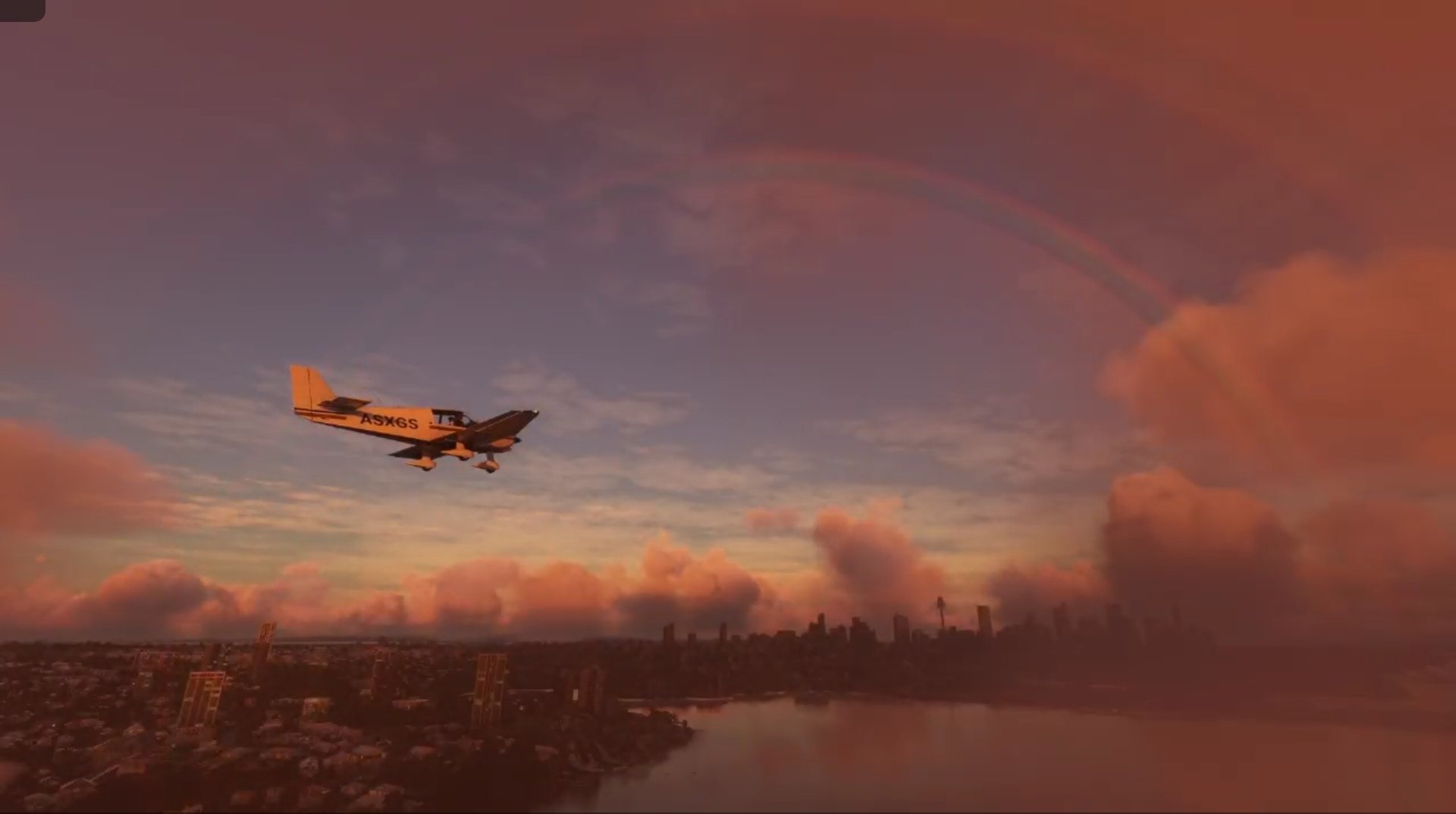 A DR-400 flies over a cityscape with a rainbow ahead