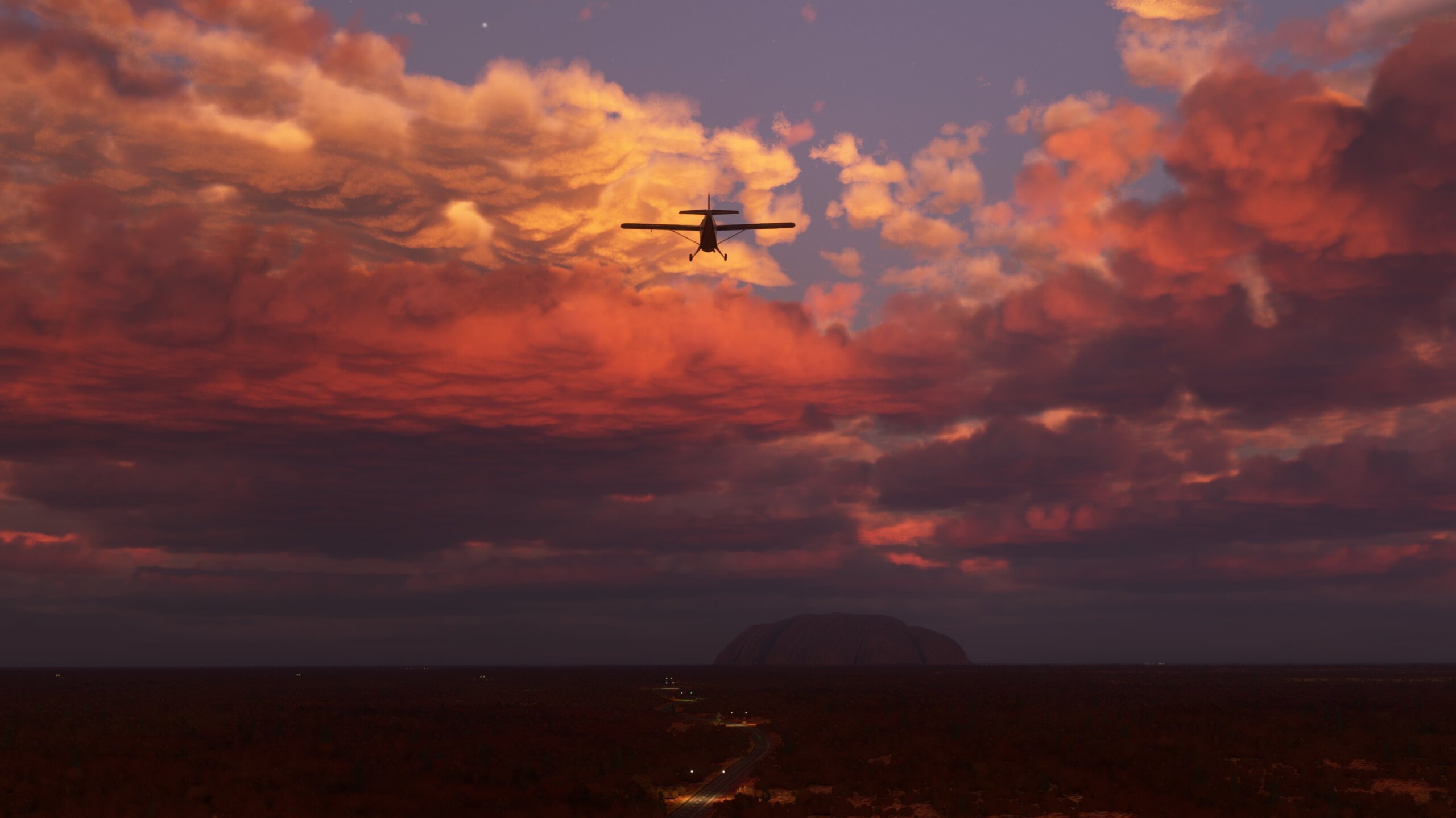 A propeller aircraft flies towards Ayers Rock, Australia