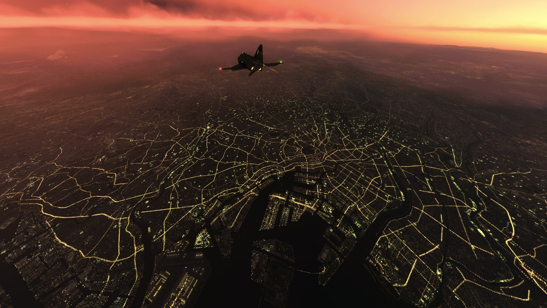 A McDonnell Douglas F-4 Phanton flies over a city at night.