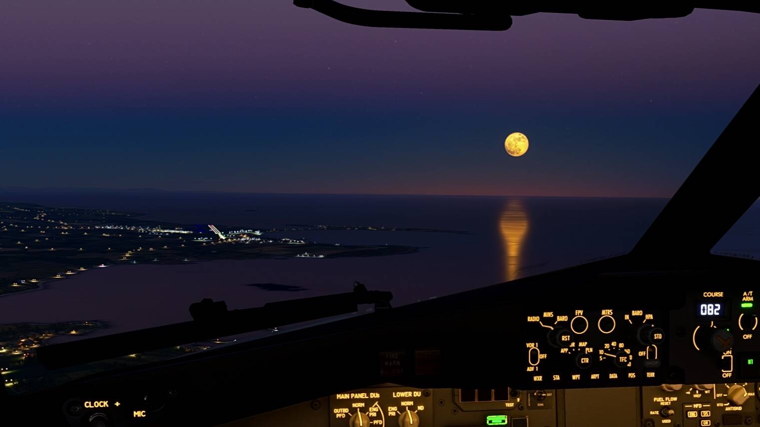 Interior flight deck view of an airliner approaching a runway at night. There is a full moon in the background.