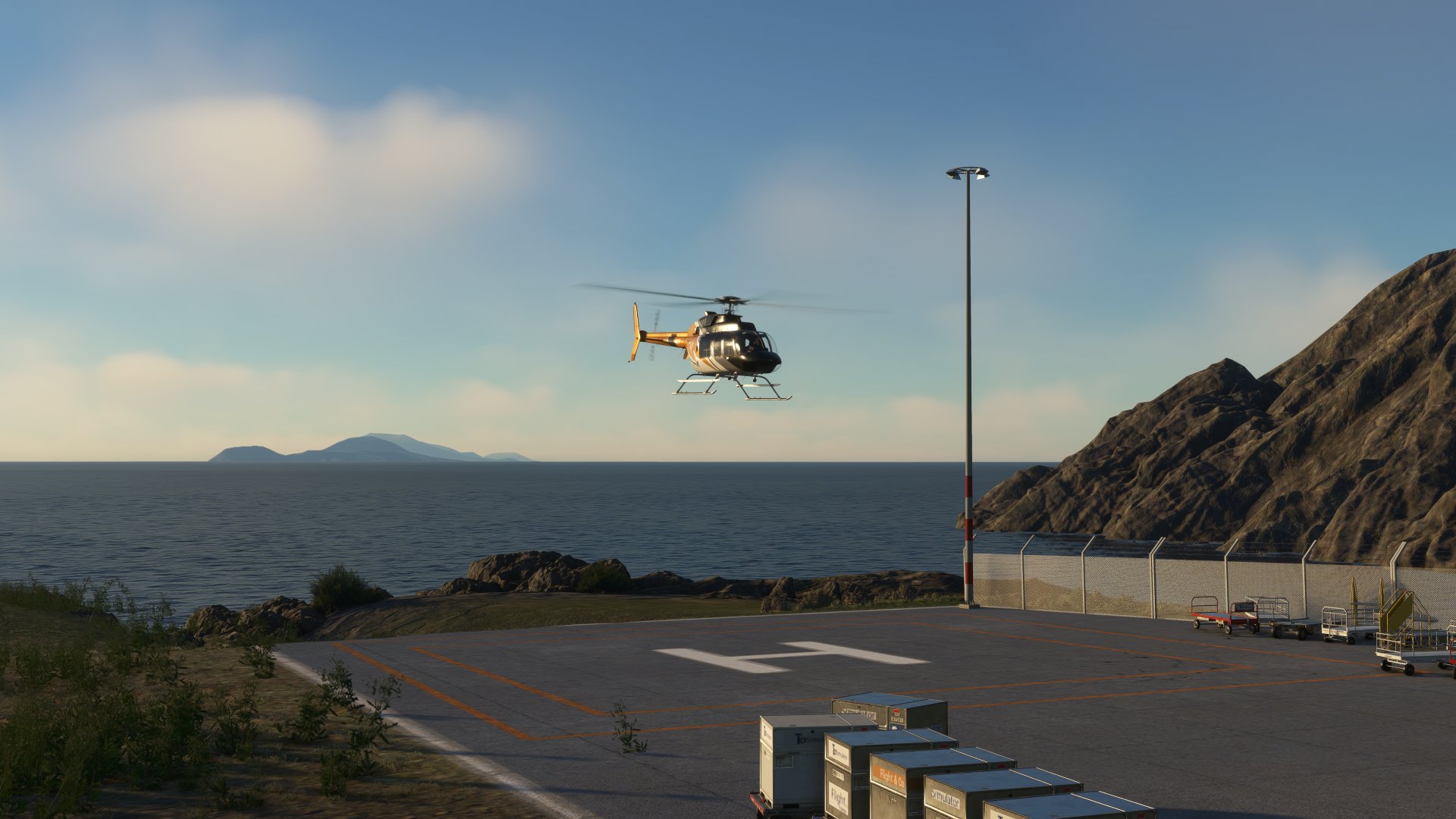 A Bell 407 hovering over a helipad