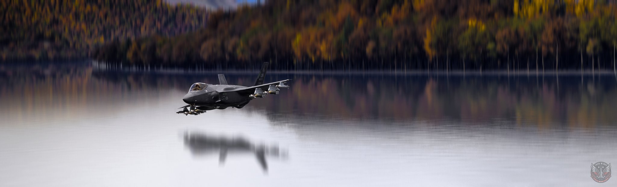 An F-35 passes low over water