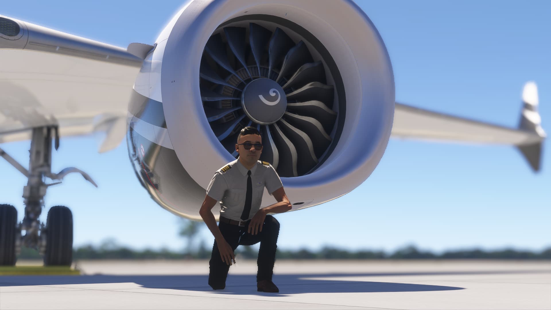 An airliner pilot kneels in front of the engine of a Boeing 737 MAX