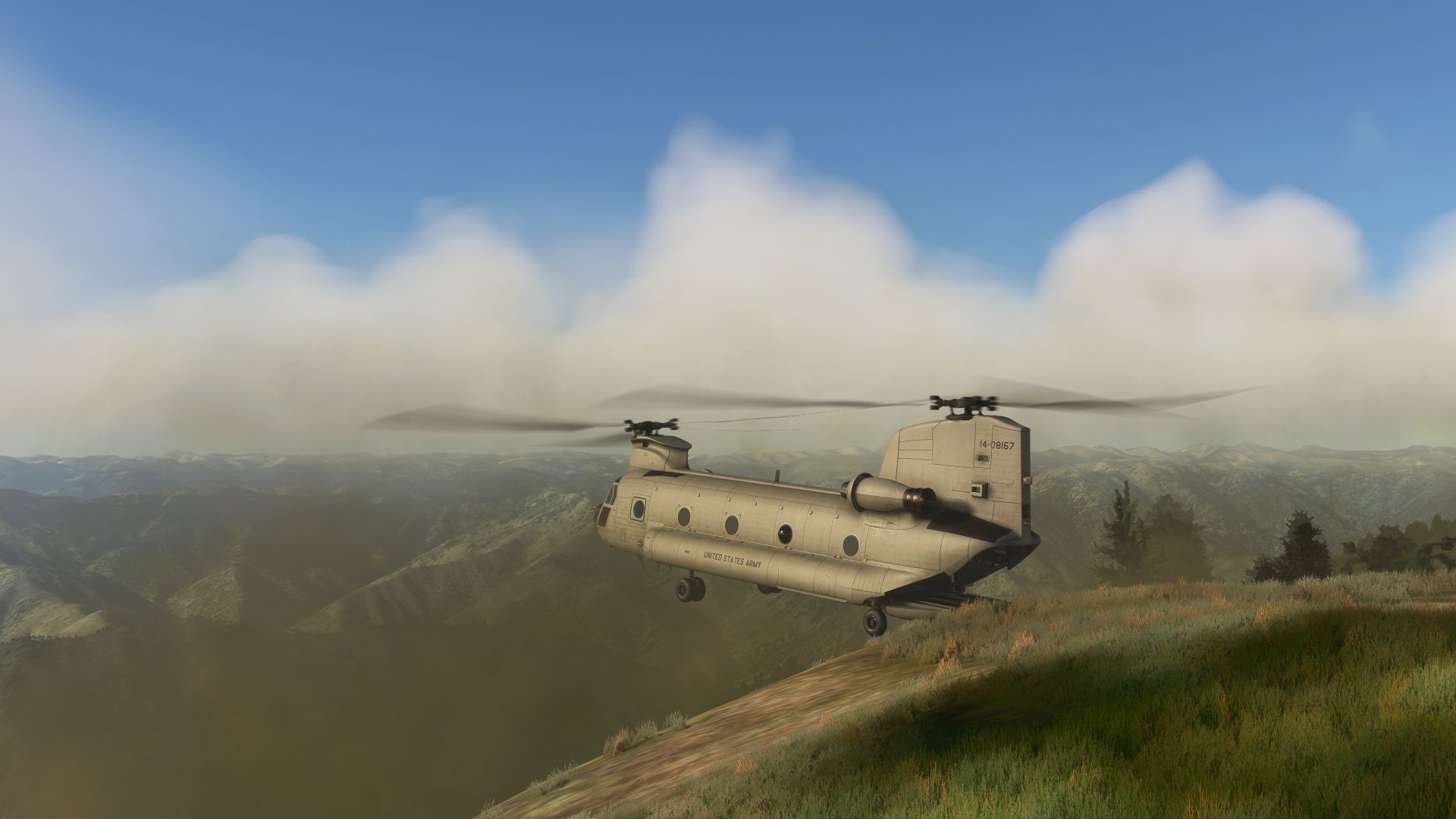 A Chinook helicopter hovers in place with ramp lowered on the edge of a hill