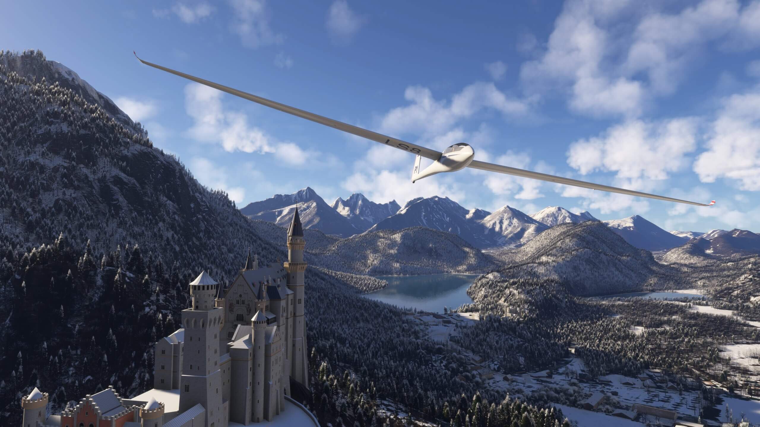 A Glider flies next to a castle in amongst a snowy mountain range