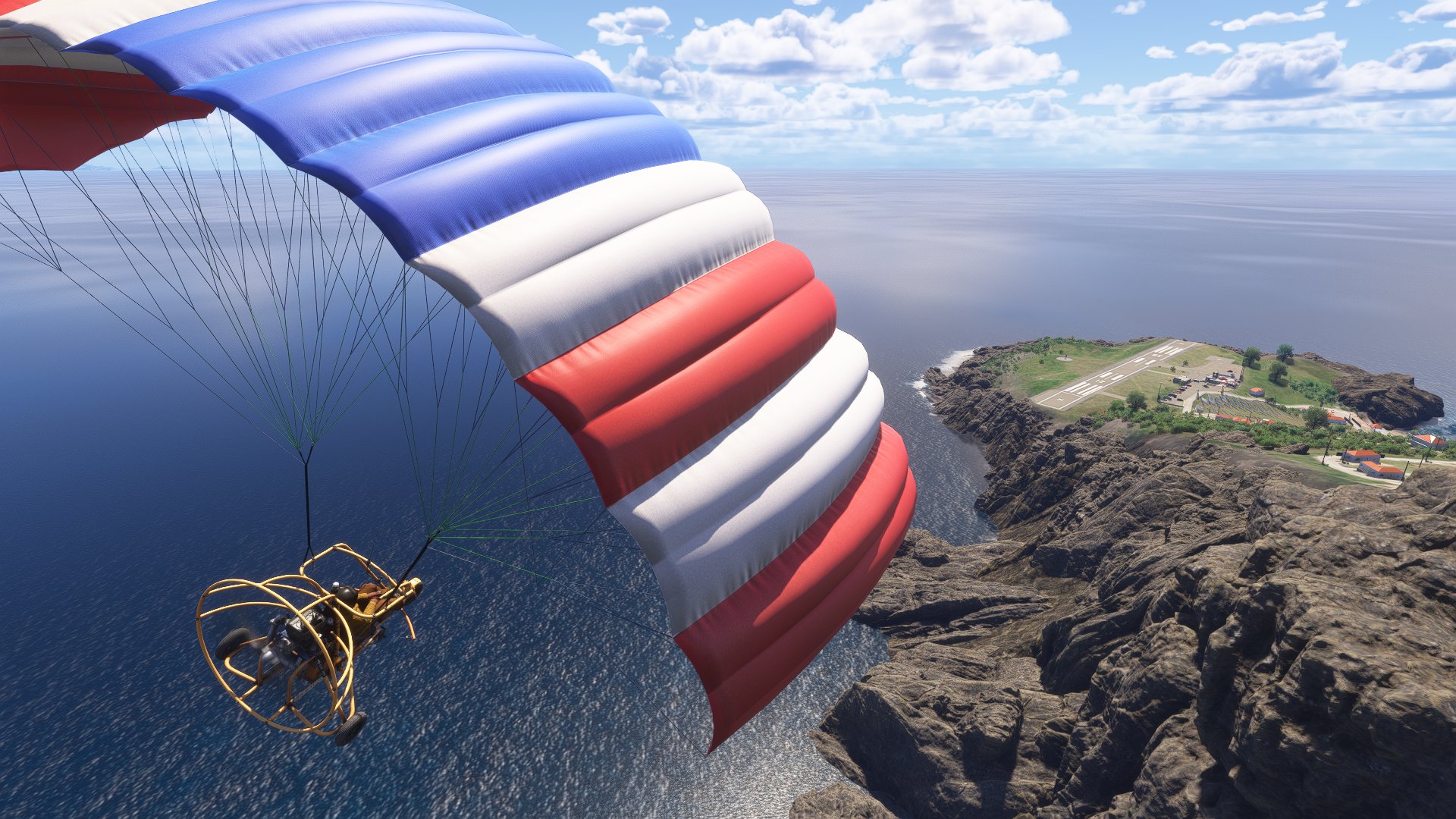 A Paraglider banks right towards an island airport in the Caribbean