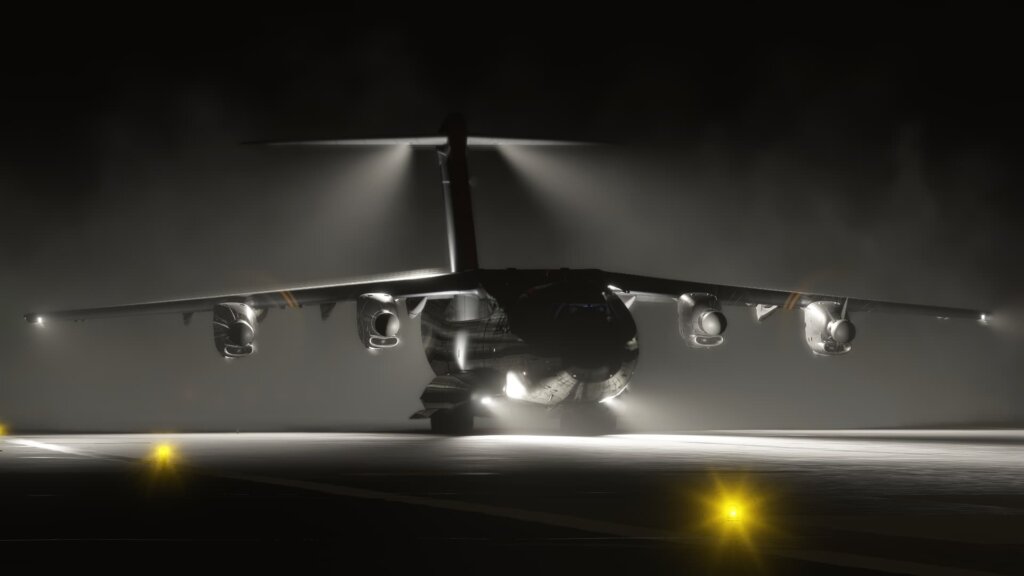 An A400M at night with landing lights illuminating the runway below