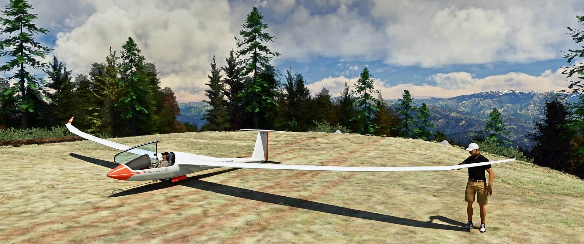 A pilot sits in the cockpit of a glider whilst another person checks the wings on a grass runway