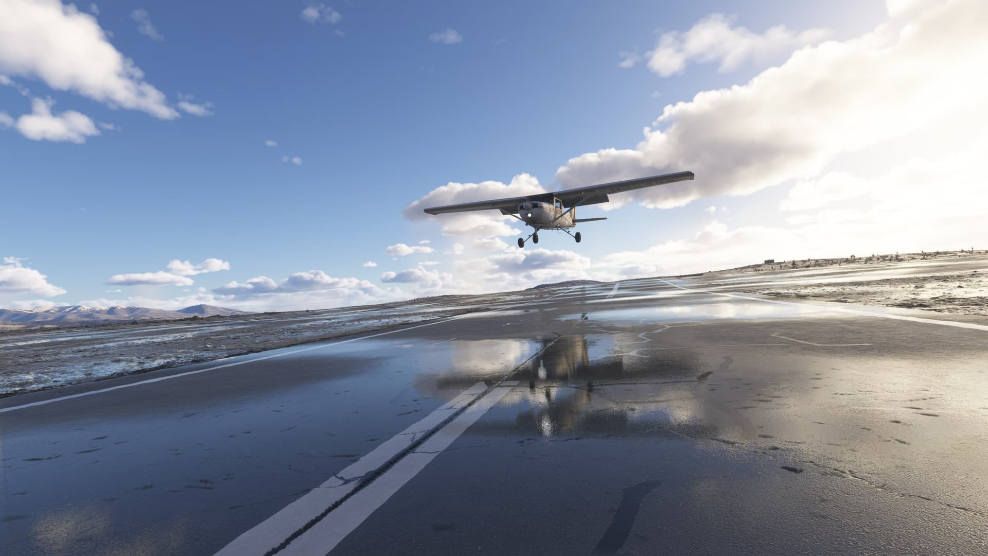 A Cessna 152 comes into land on a patchy wet runway below