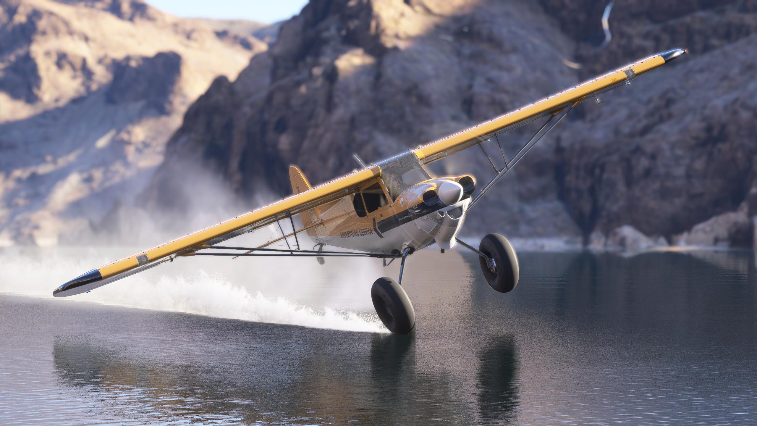 An XCub makes contact with the water below with its right wheel as it flies close to the surface