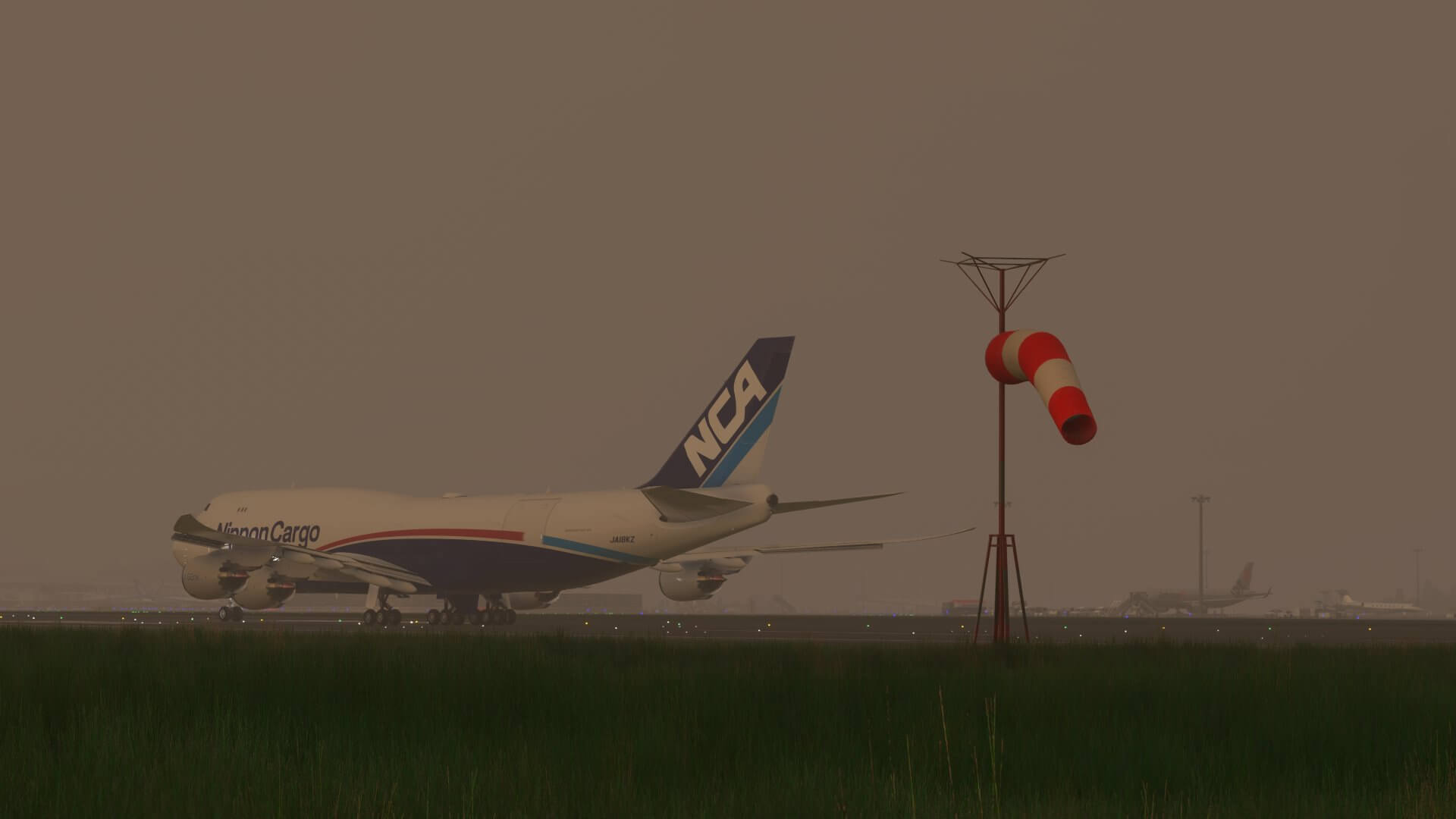 A Nippon Cargo Boeing 747 taxis at an airport with a windsock blowing in the wind