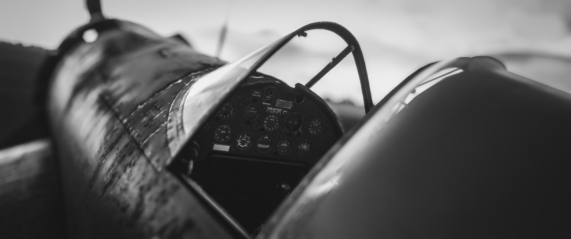 A black and white screenshot looking into an aircraft cockpit.