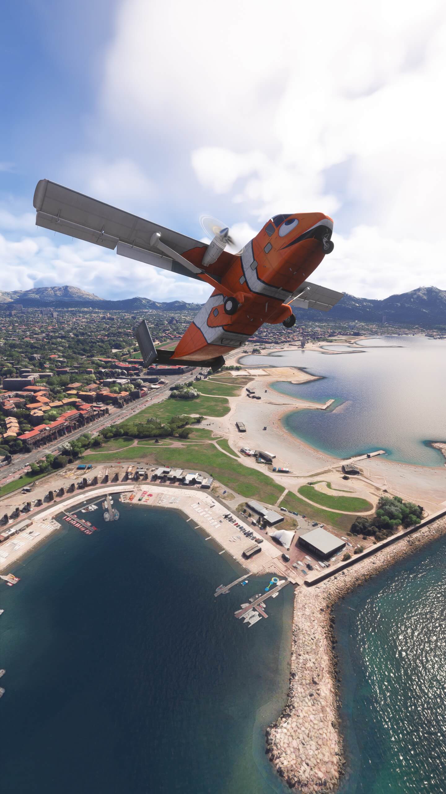 A Skyvan in orange fish livery climbs steeply over a coastal city