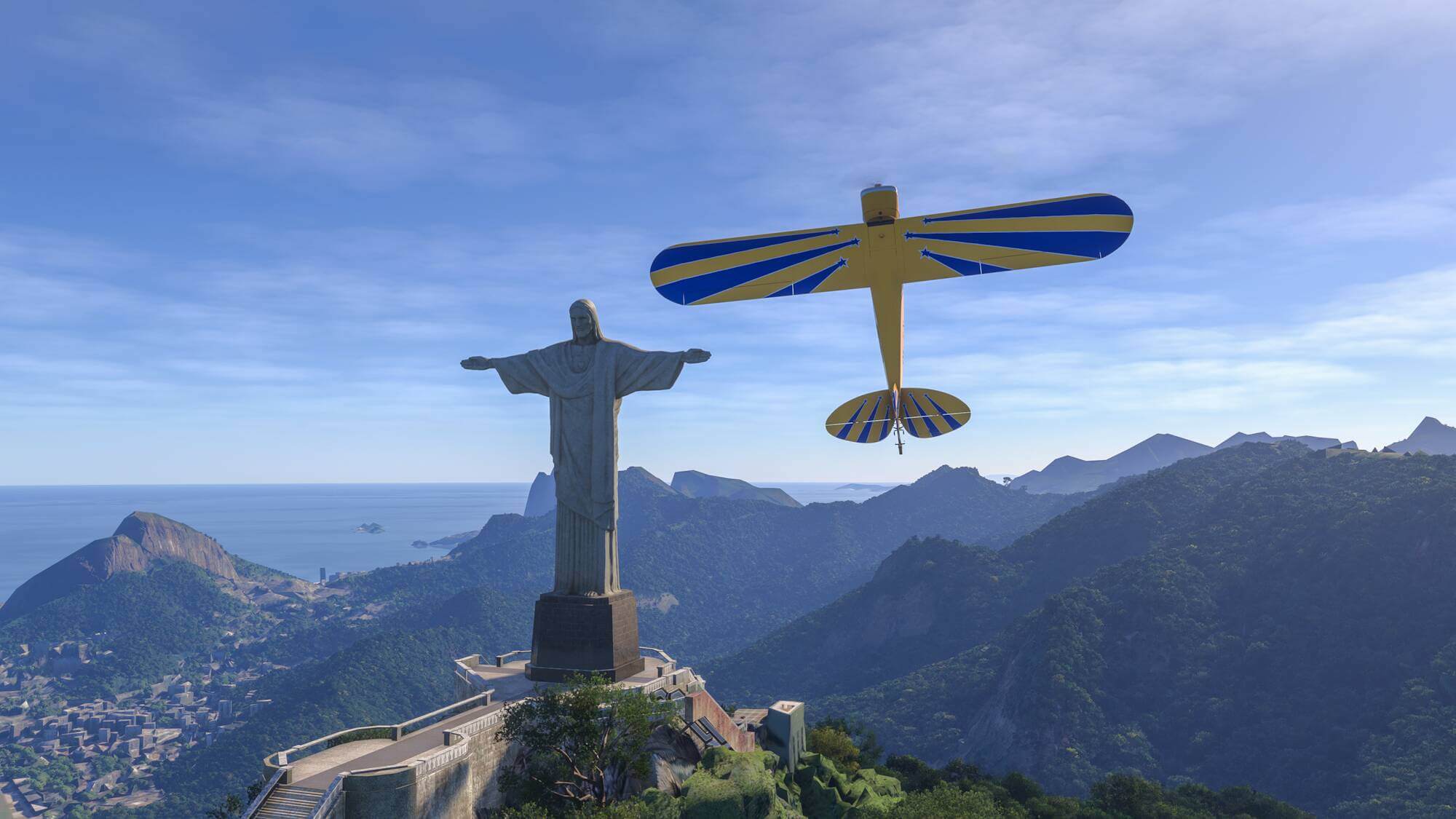 A yellow and blue aerobatic aircraft flies vertically next to the Christ The Redeemer Statue in Rio De Janeiro