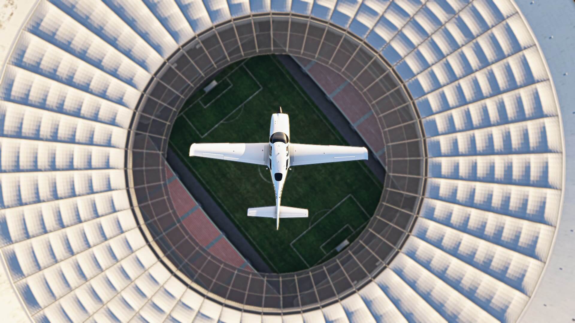 a low wing white propeller aircraft flies directly above the football pitch at the Mane Garrincha Stadium in Brasilia