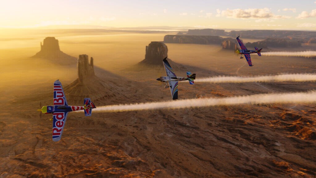 Three aircraft race against each other above the desert.