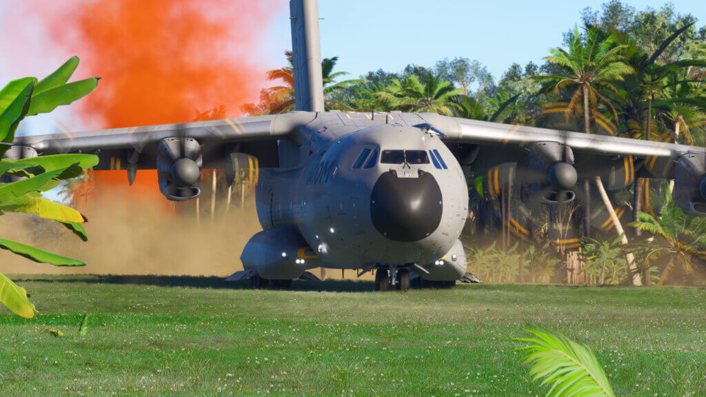 A large cargo transport aircraft lands on a grass airstrip.