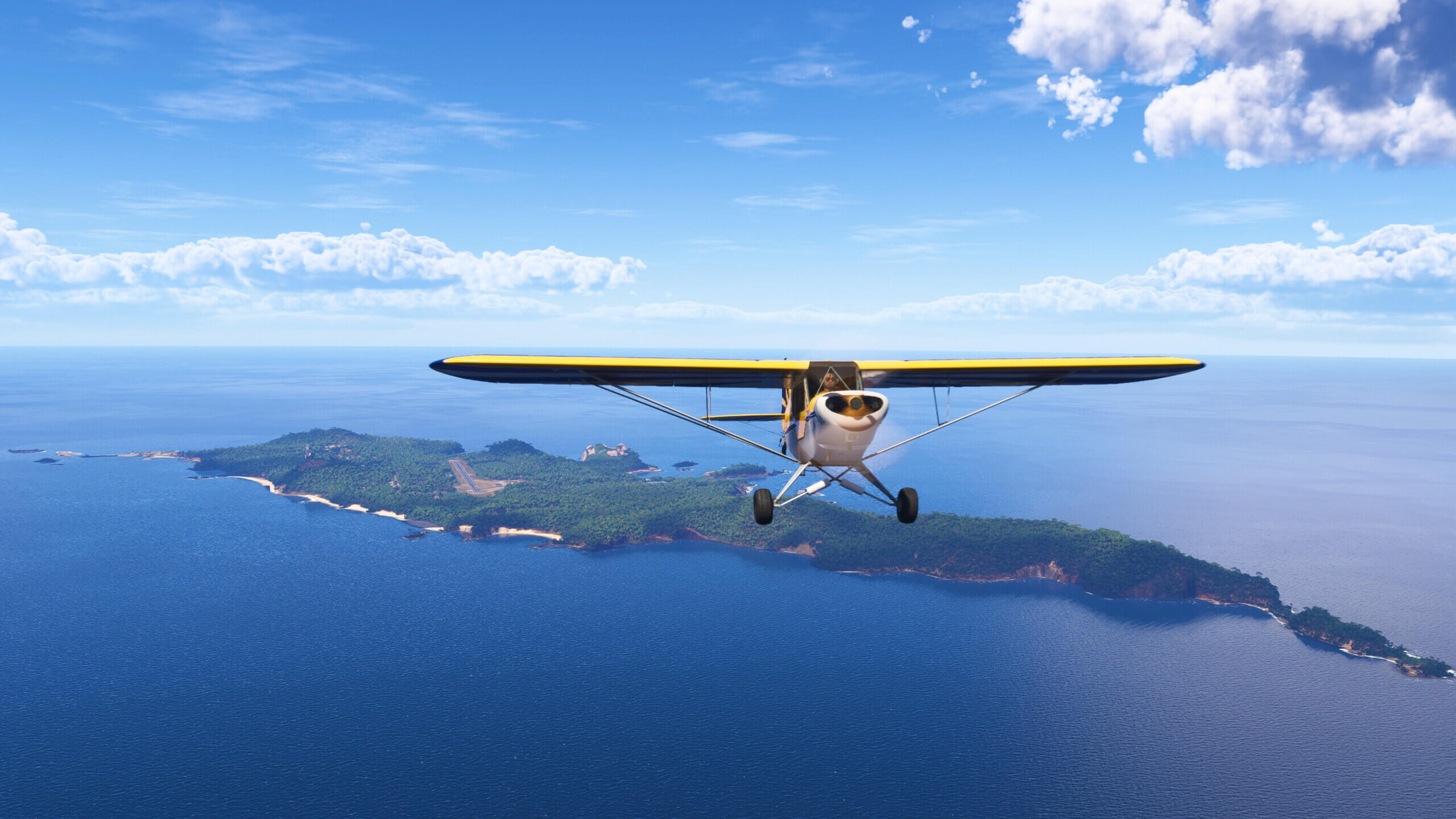 A CAP-4 Paulistinha flies above an island on a sunny day.