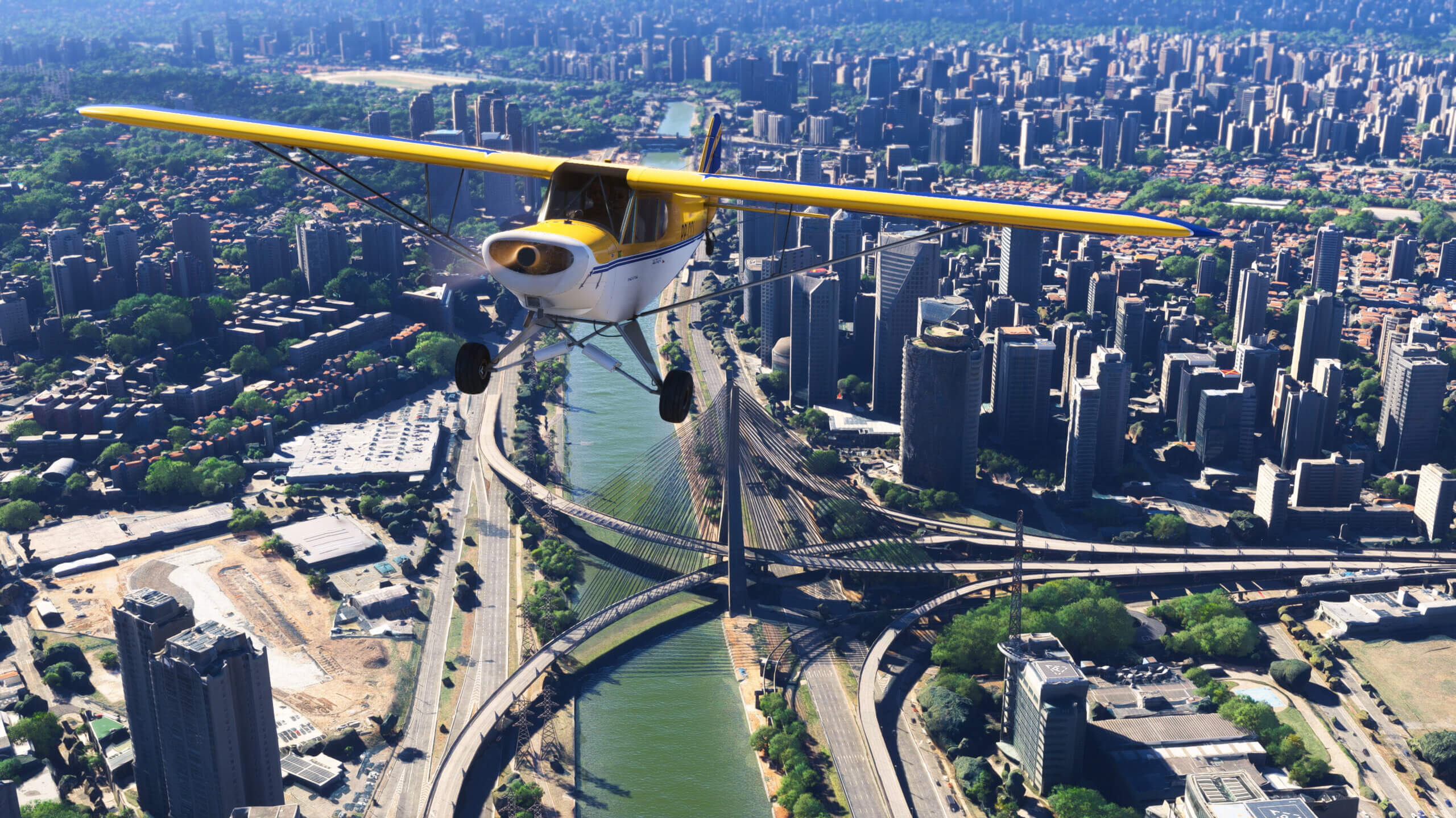 A CAP-4 Paulistinha flying above a city divided by a river.