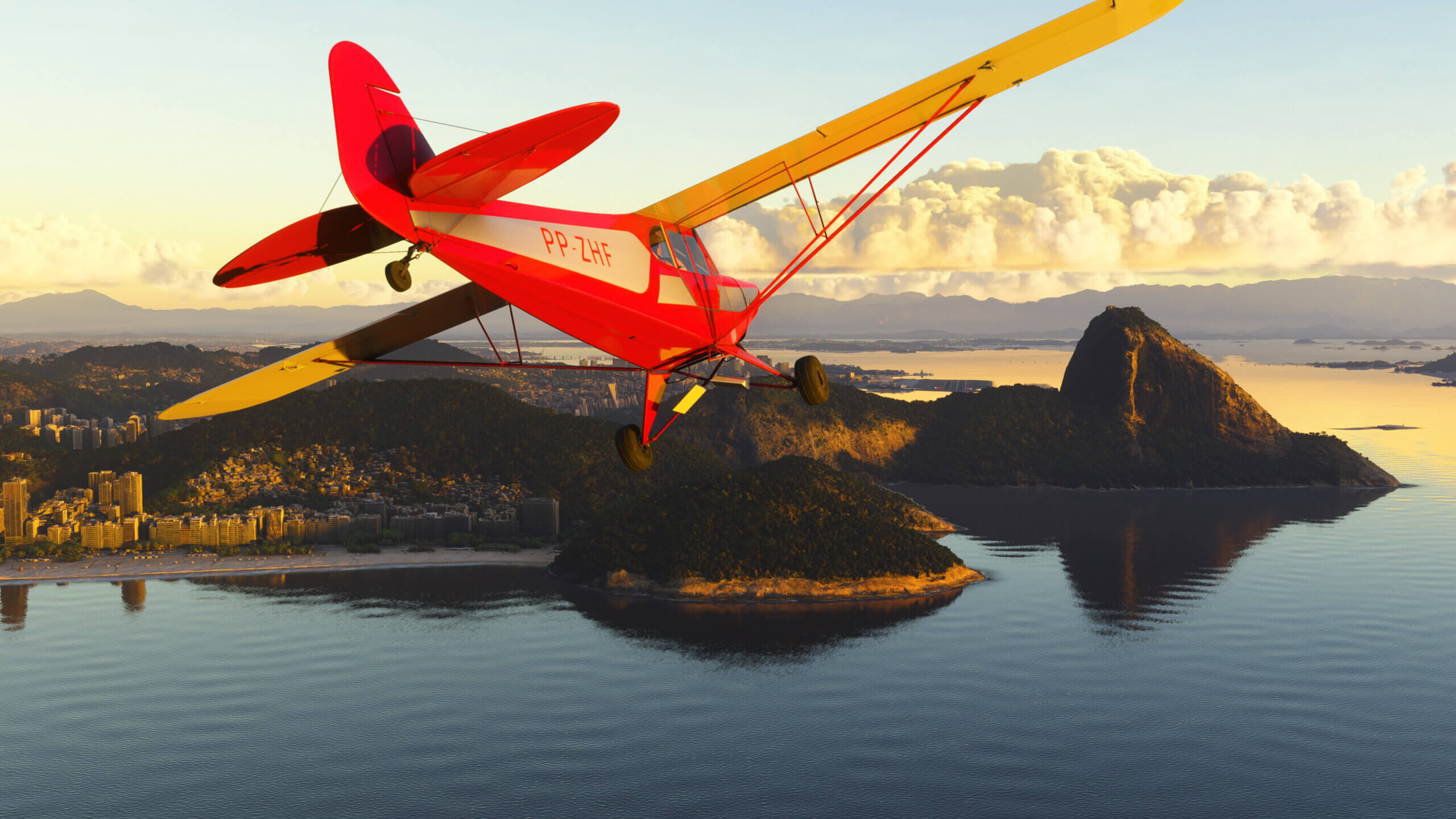 A red CAP-4 Paulistinha flies towards a peninsula.