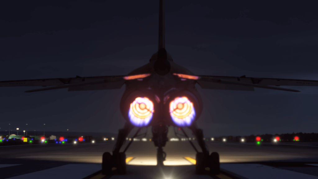A nighttime scene looking at a jet from behind as the burners warm up.