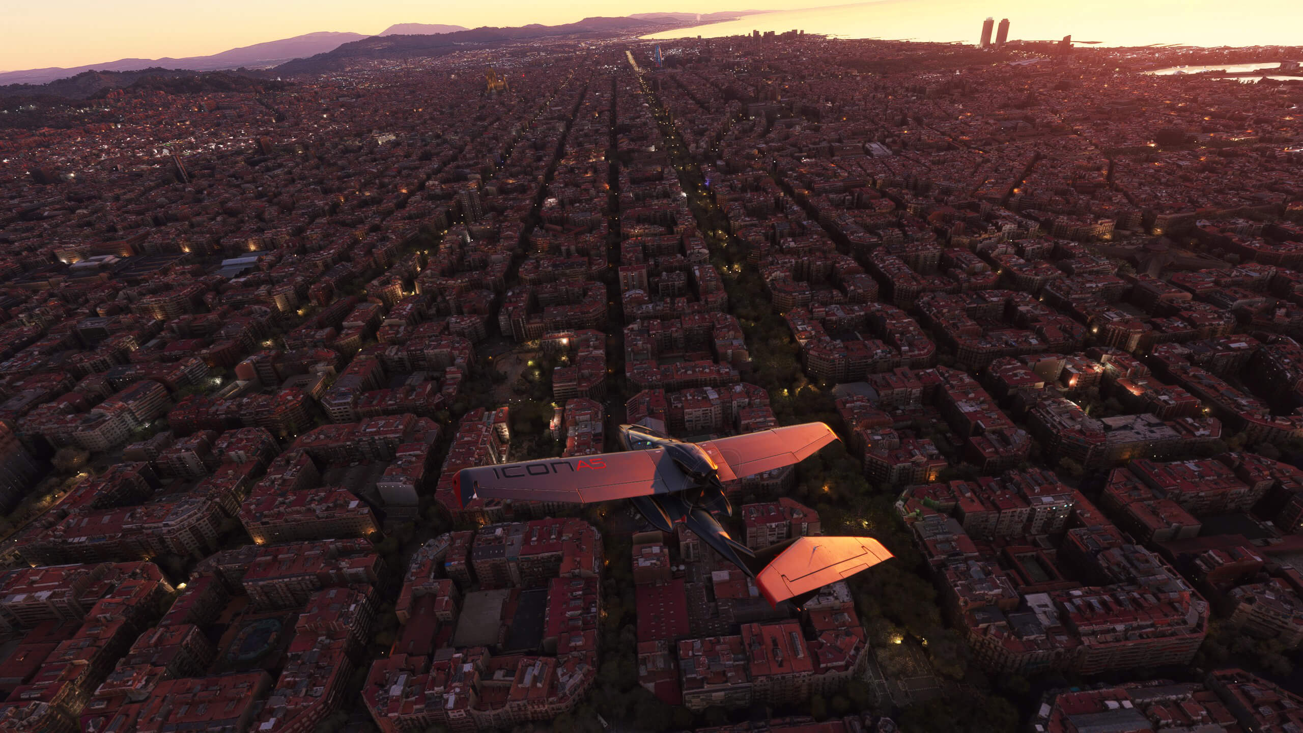 An Icon A5 flies low over a city with red building tops