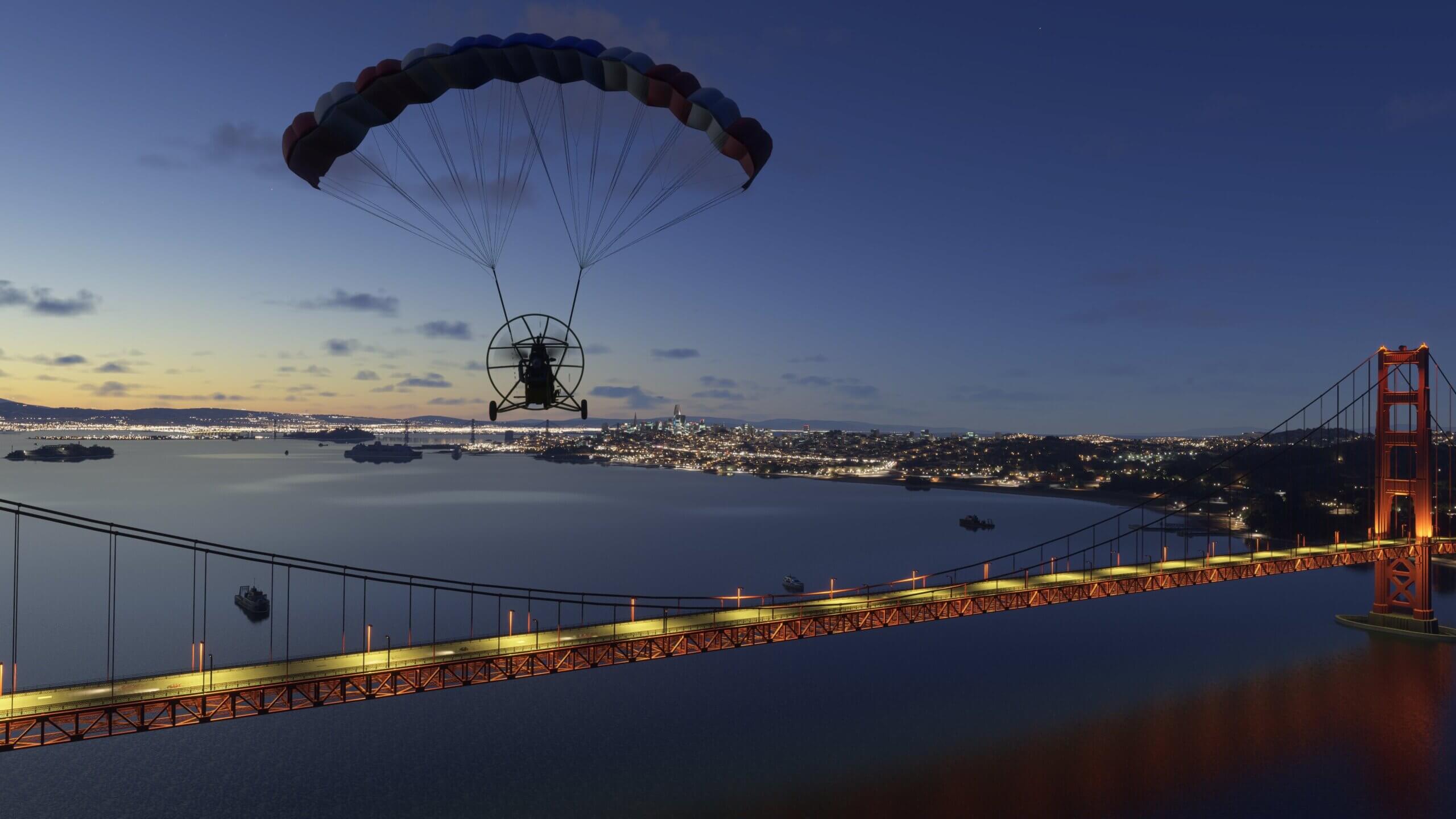 A powered parachute aircraft flies above the Golden Gate Bridge, San Francisco at night