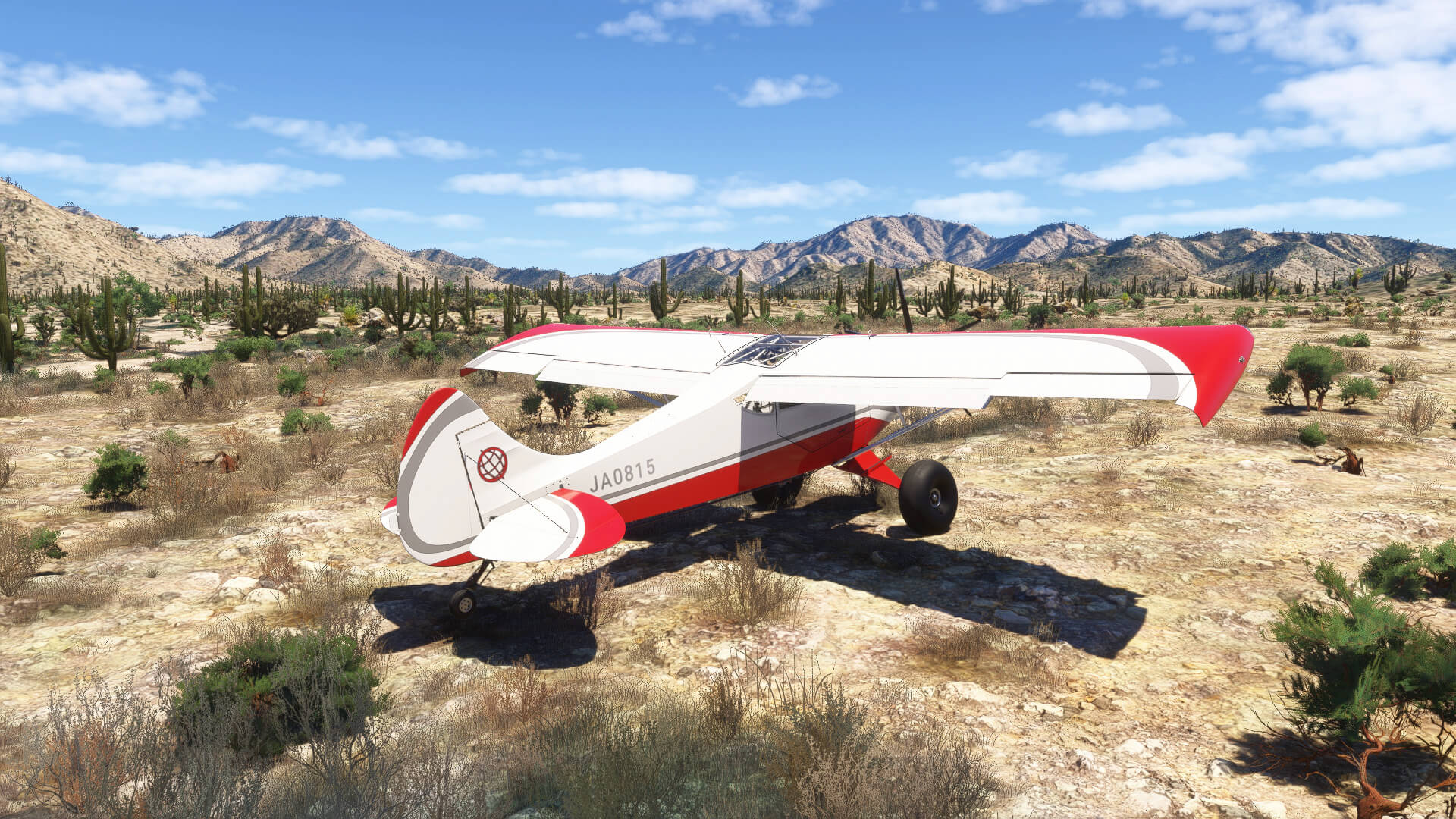 A high wing propeller aircraft in white and red color scheme parked in a desert