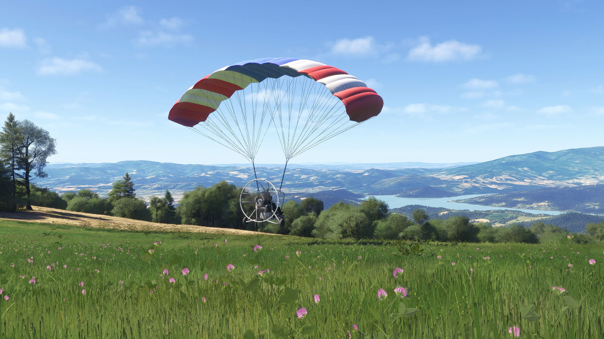 A gyrocopter passes close by a grass field whilst in flight