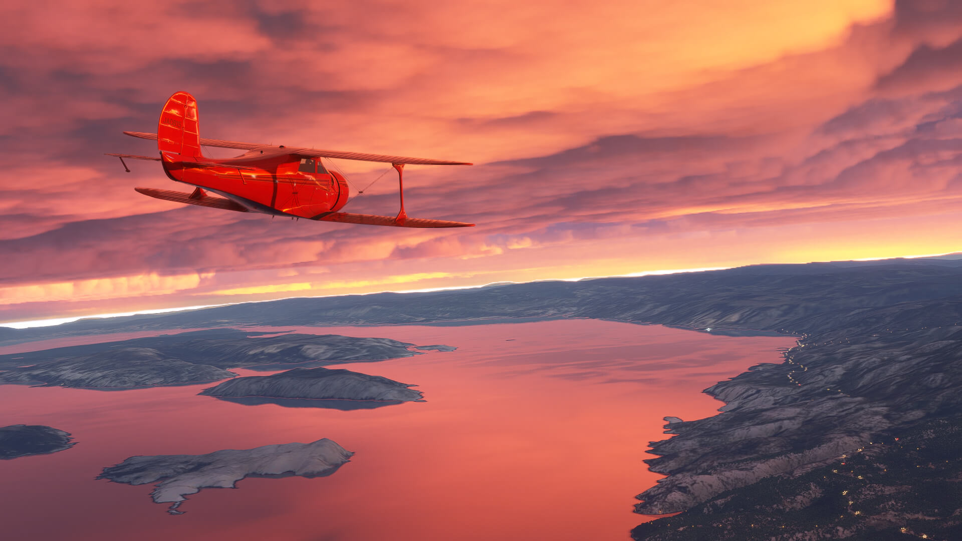 A dual wing propeller aircraft aircraft flies high over terrain and water during sunset