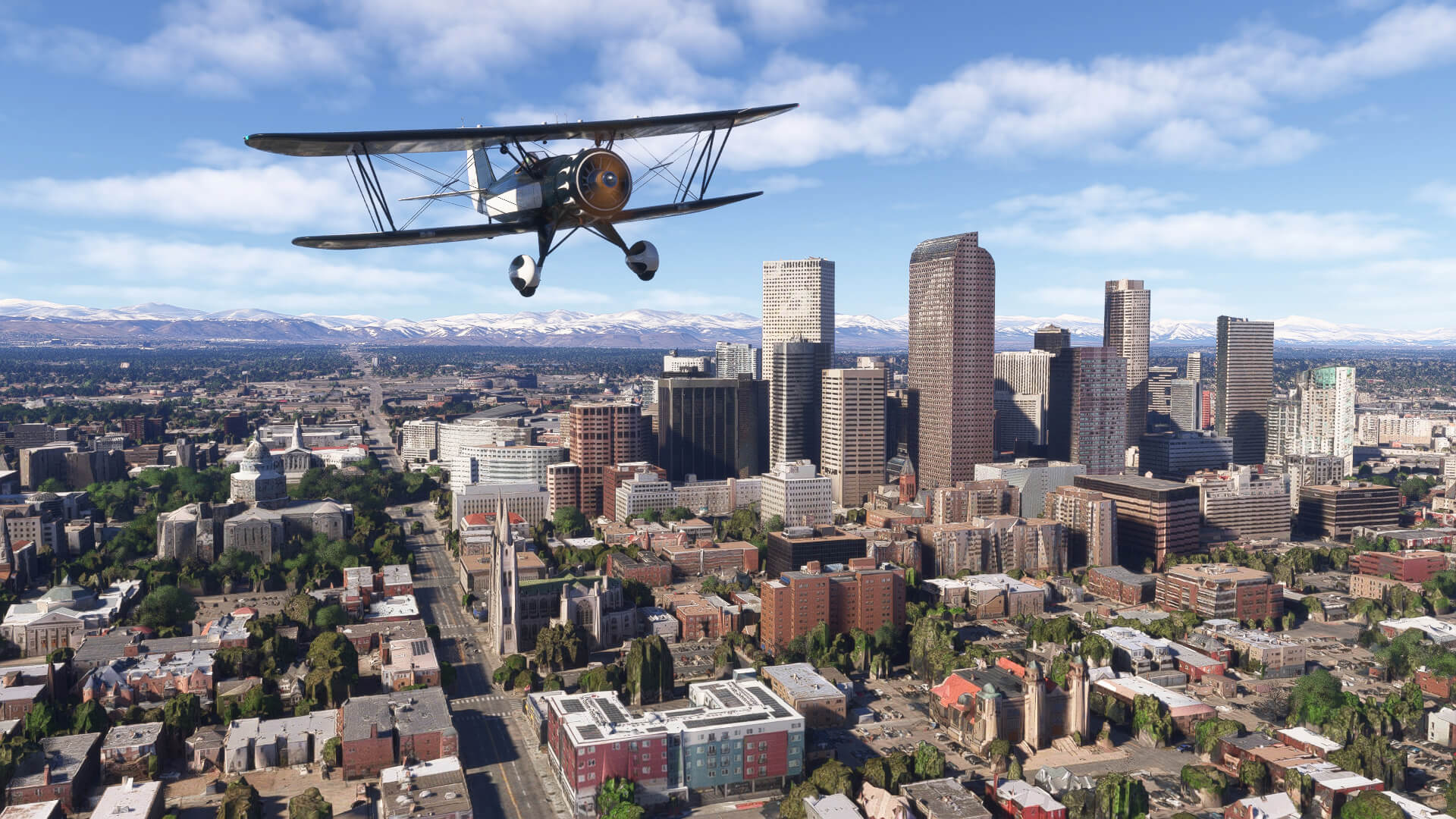 A dual wing black propeller aircraft flies above Denver city