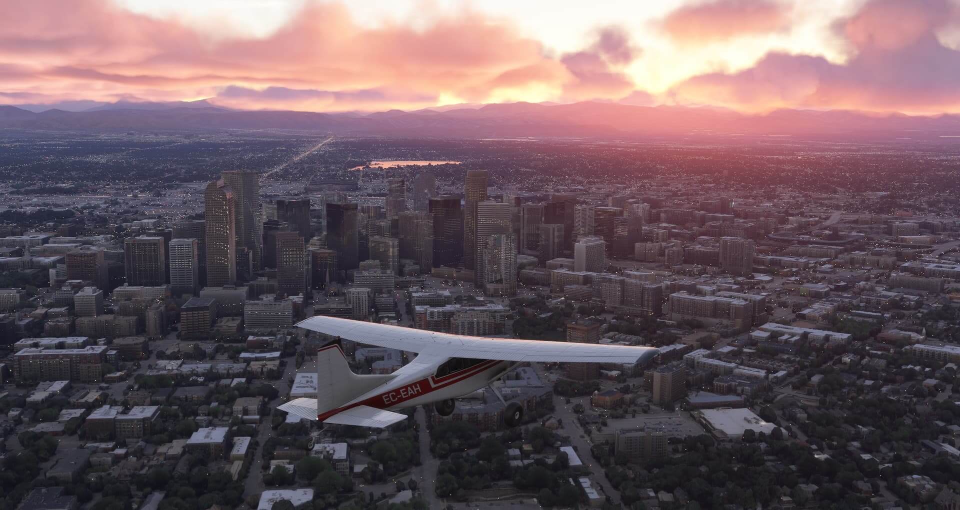 A Cessna propeller aircraft flies over a cityscape during sunset