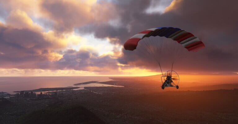 A powered parachute aircraft flies towards the city of Honolulu, Hawaii during sunset