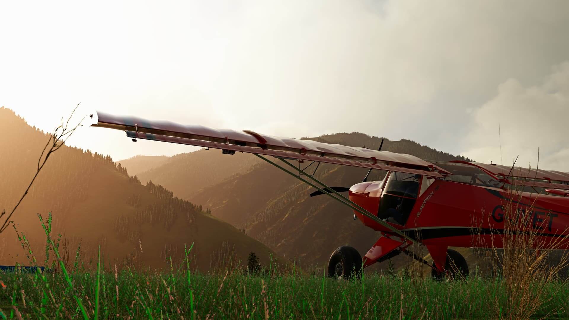 A red Kitfox sits idle on a grass strip