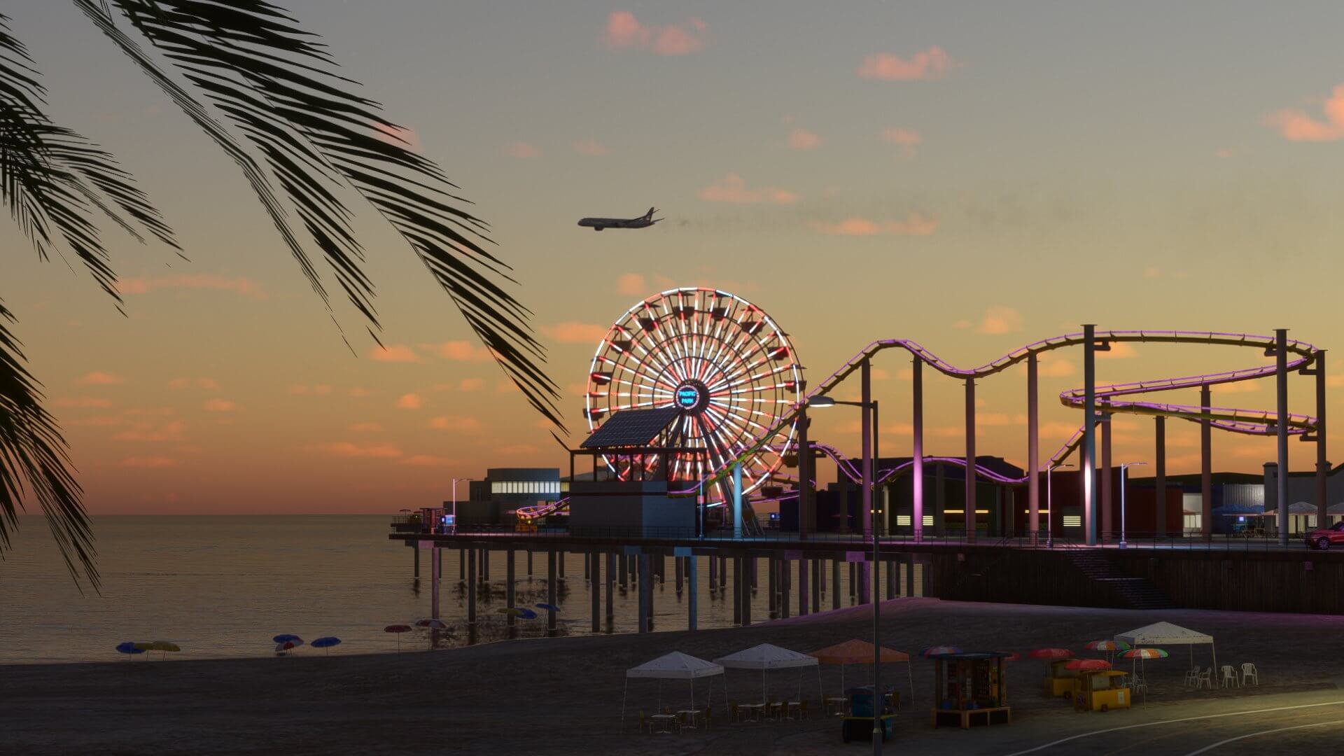 An airliner flies above Santa Monica Pear during sunset