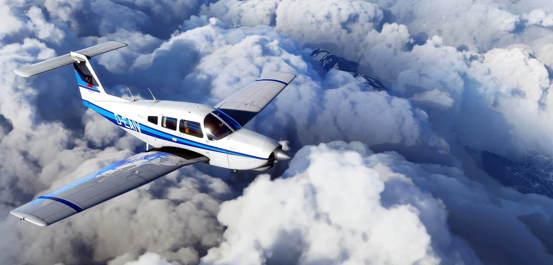 A Piper propeller aircraft cruises above steep terrain and thick clouds