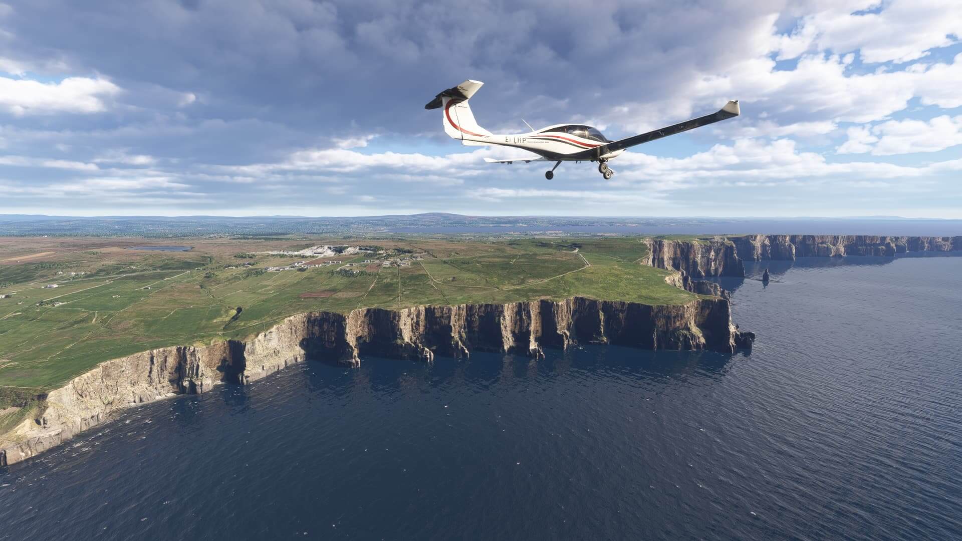 A low wing propeller aircraft flies with wings level past a steep cliff line
