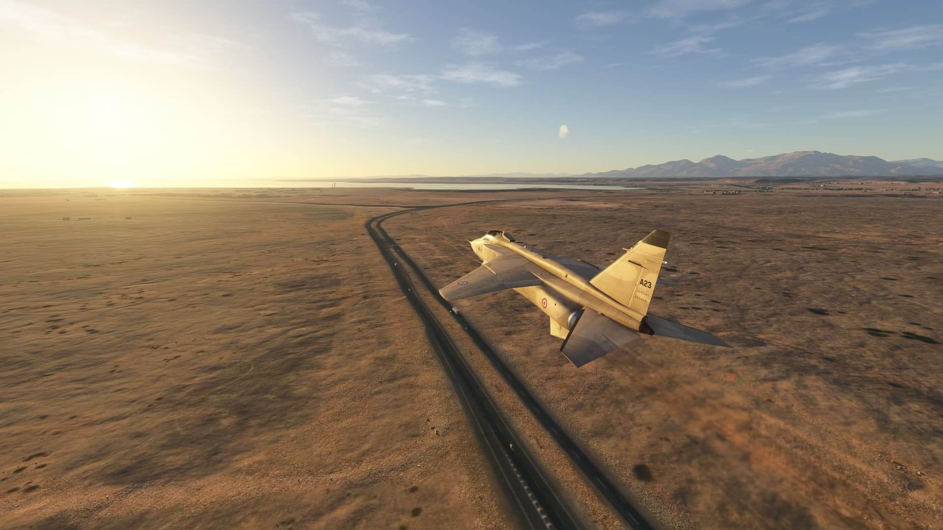 A jet flies above a desert towards a distant shore.