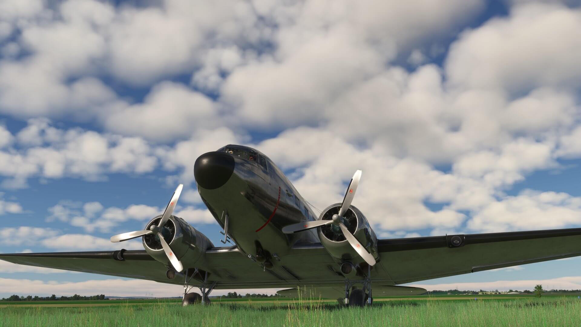 A DC-3 sits idle on a grass taxiway