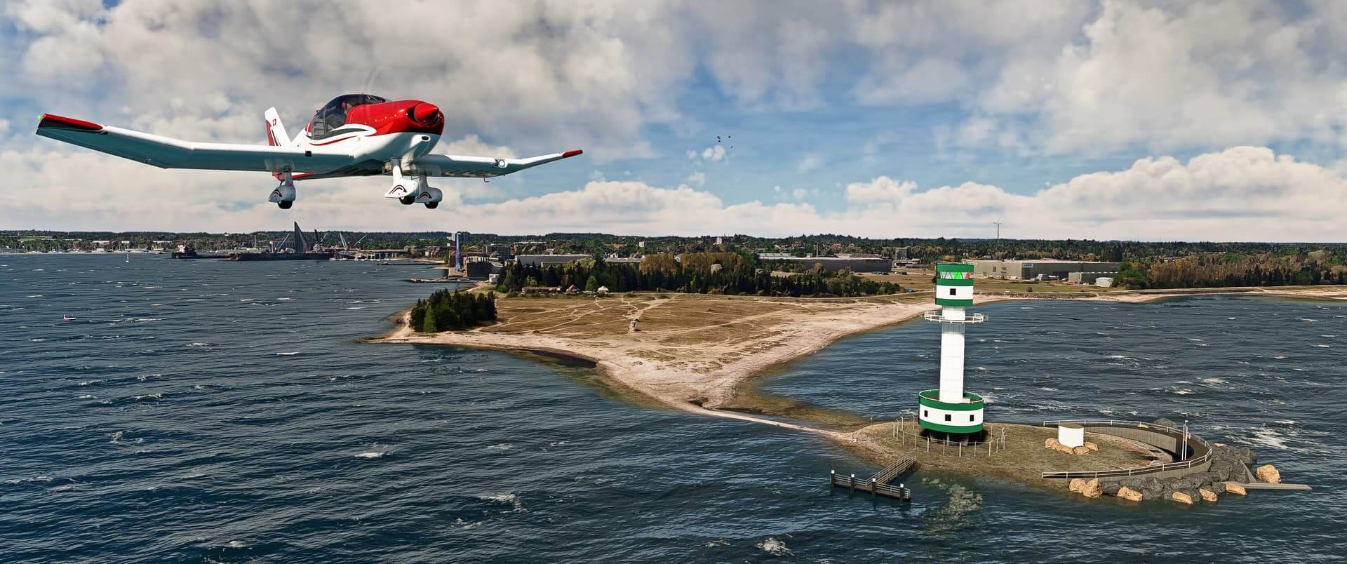 A DR-40 flies low over water near a green and white lighthouse