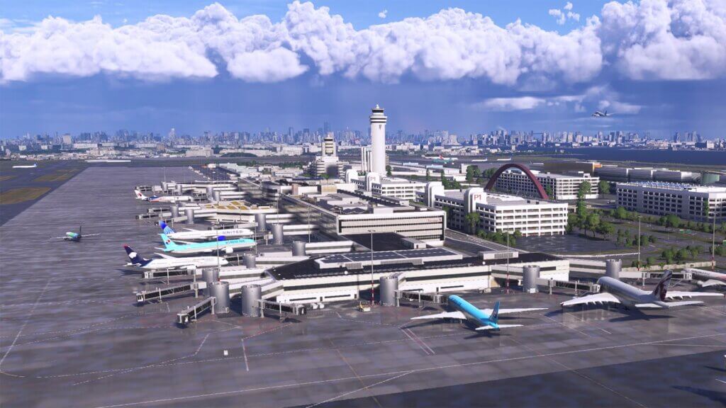An airport with a view of the control tower with a storm in the background