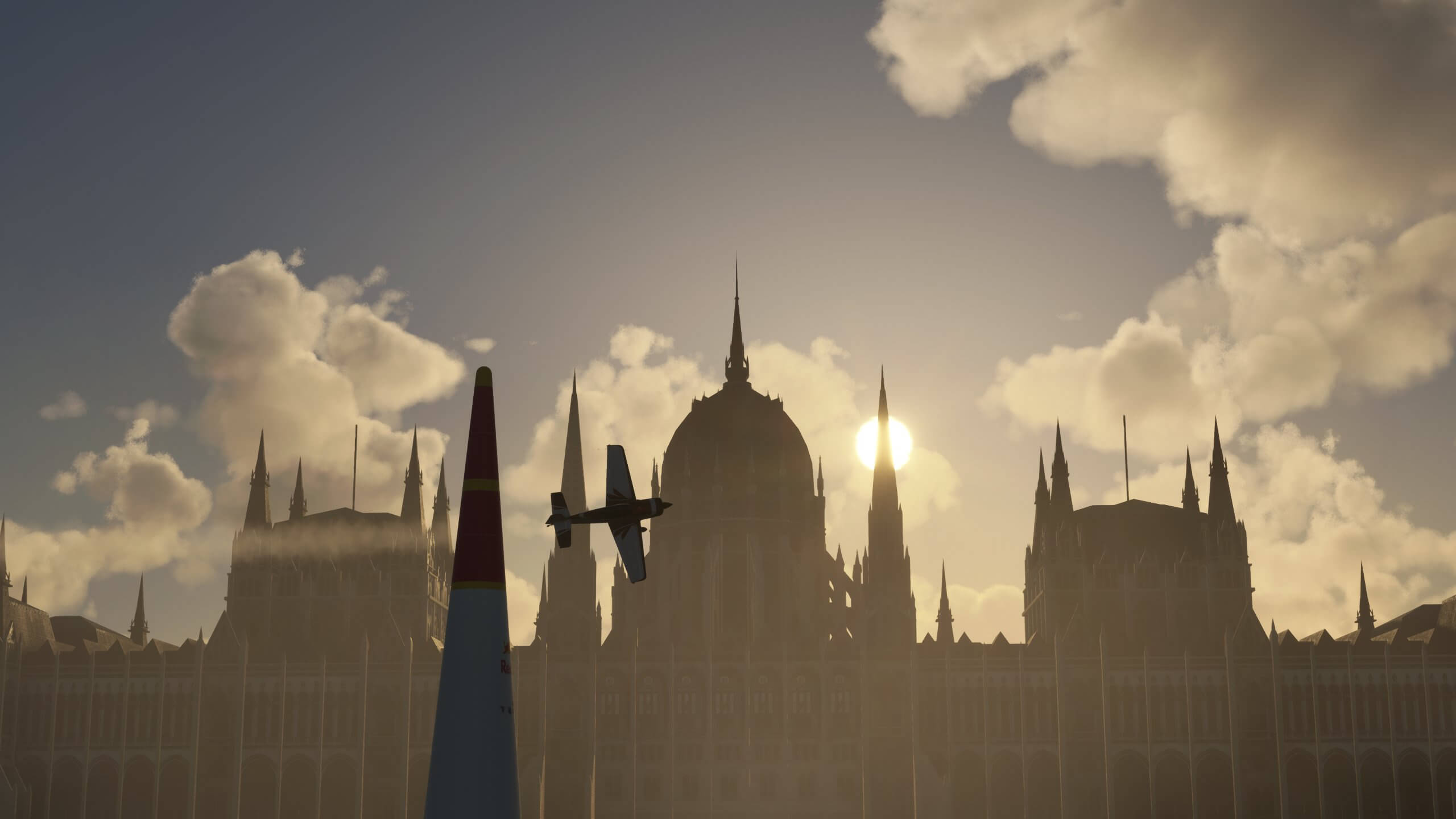 An Extra 330 aircraft completes a race course with a historic building silhouetted behind