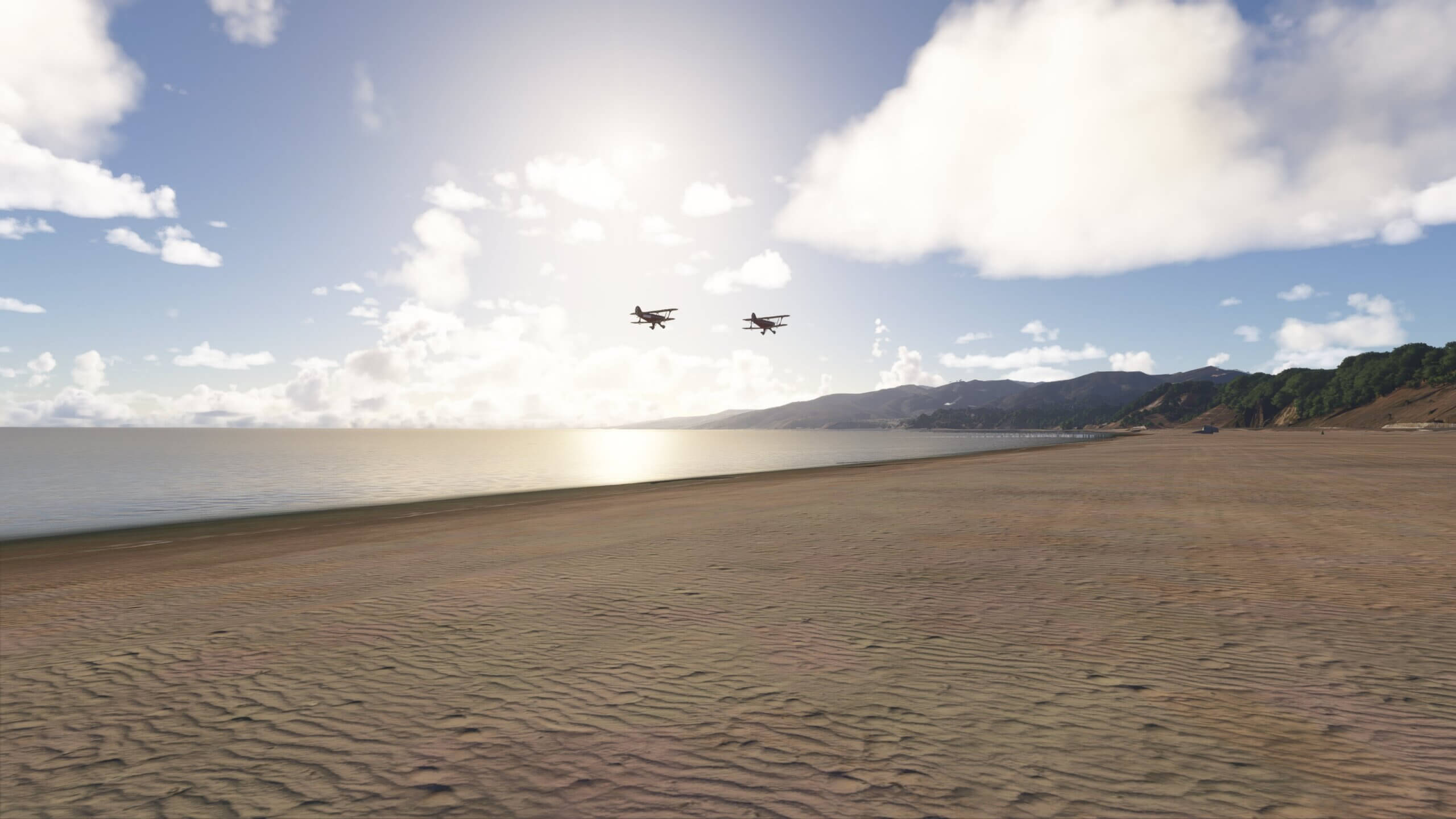 Two dual-wing propeller aircraft fly in close formation down a beachfront