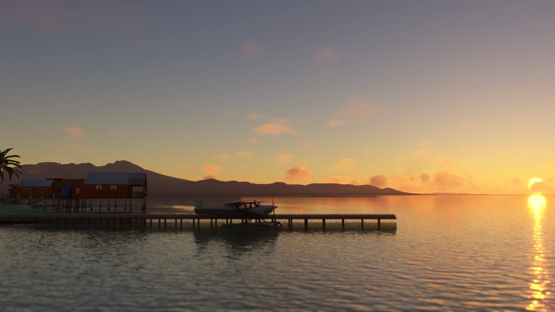 A high wing propeller aircraft parked stationary next to a jetty, with the sun setting over the water in the distance