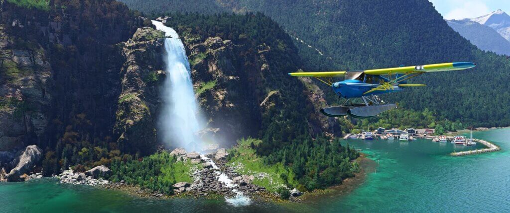 A high-wing blue and yellow propeller aircraft flies past Milford Sound waterfall in New Zealand