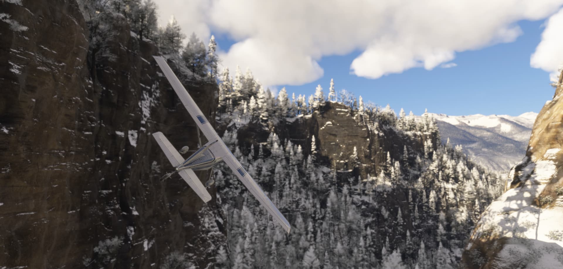 A Cessna 172 banks sharply to the right to avoid terrain whilst flying through a snowy valley