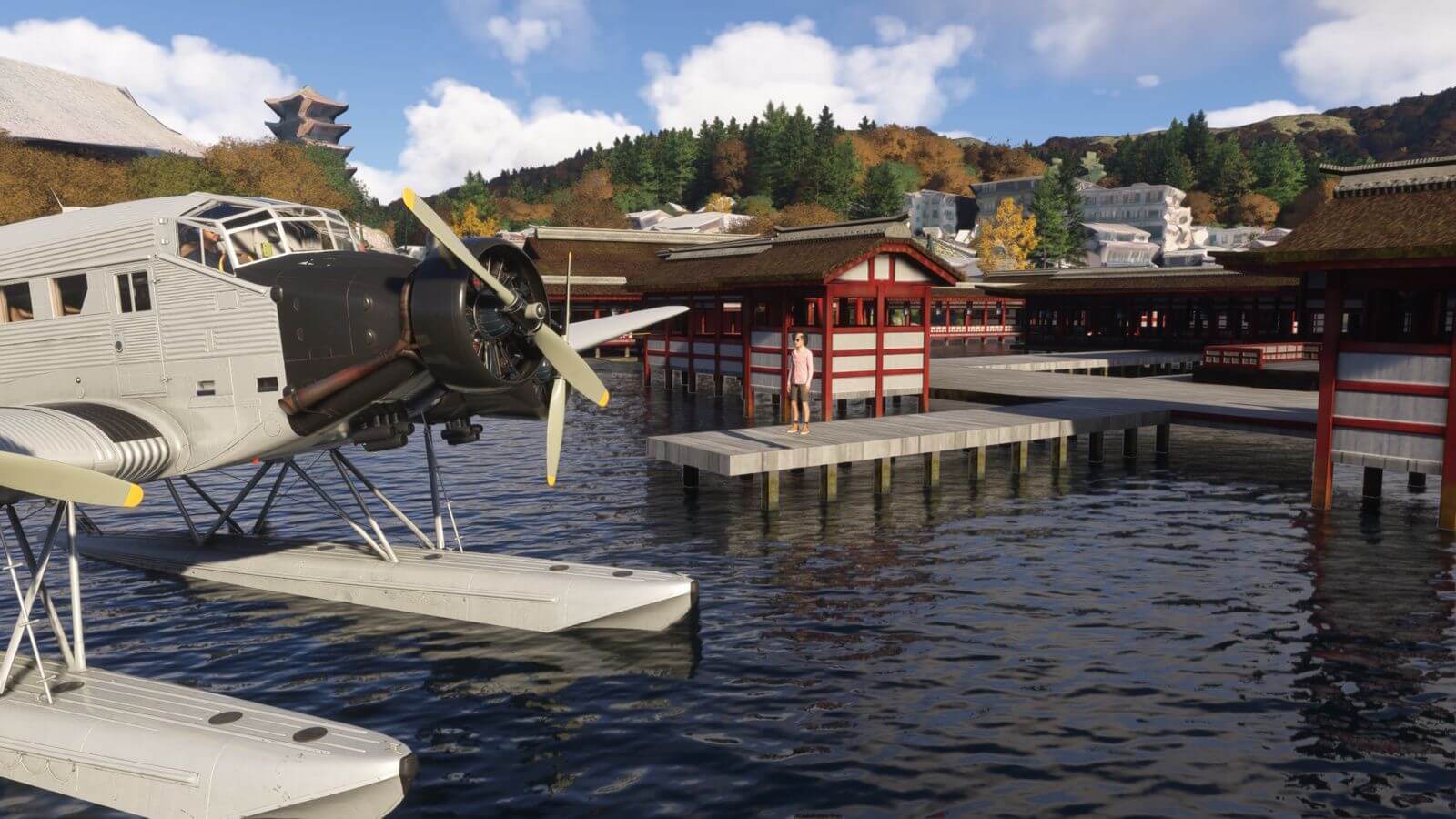 A boat plane sits idle next to a harbour as a guest waits to board