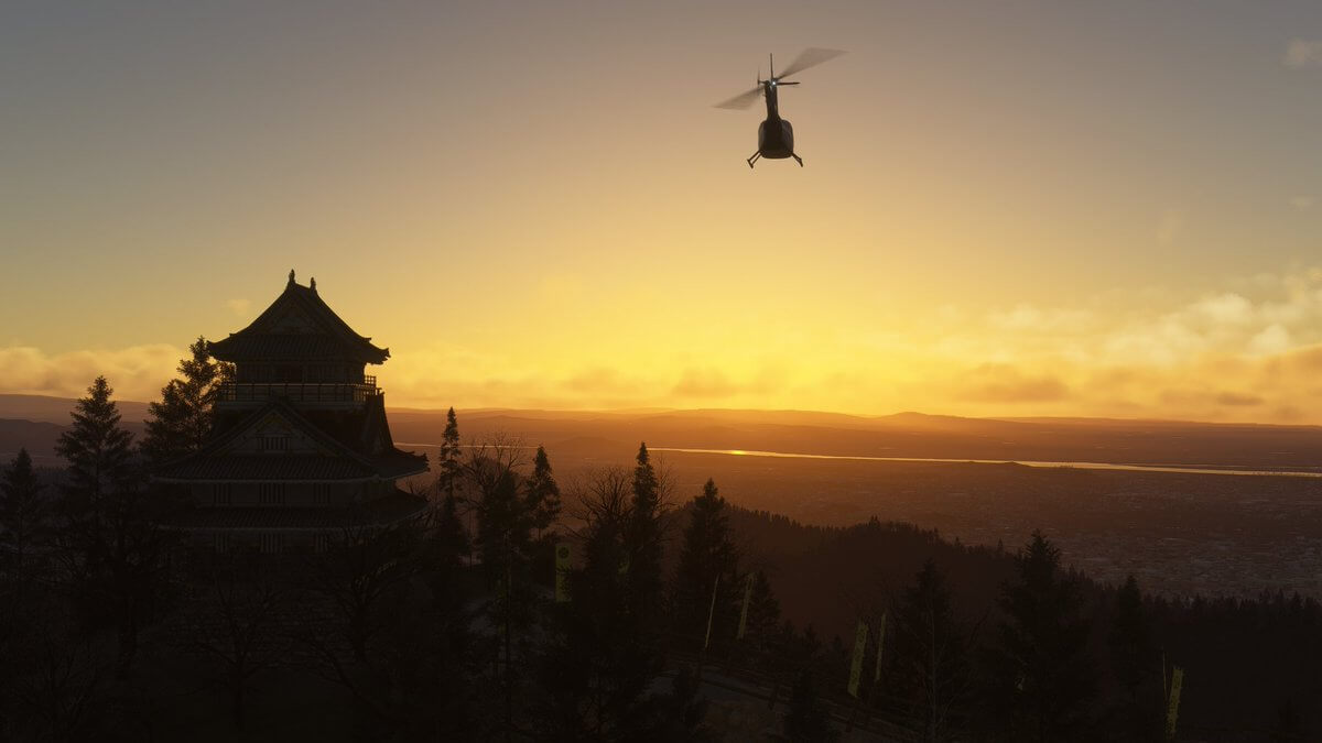 A helicopter flies over a historic Japanese building during sunset