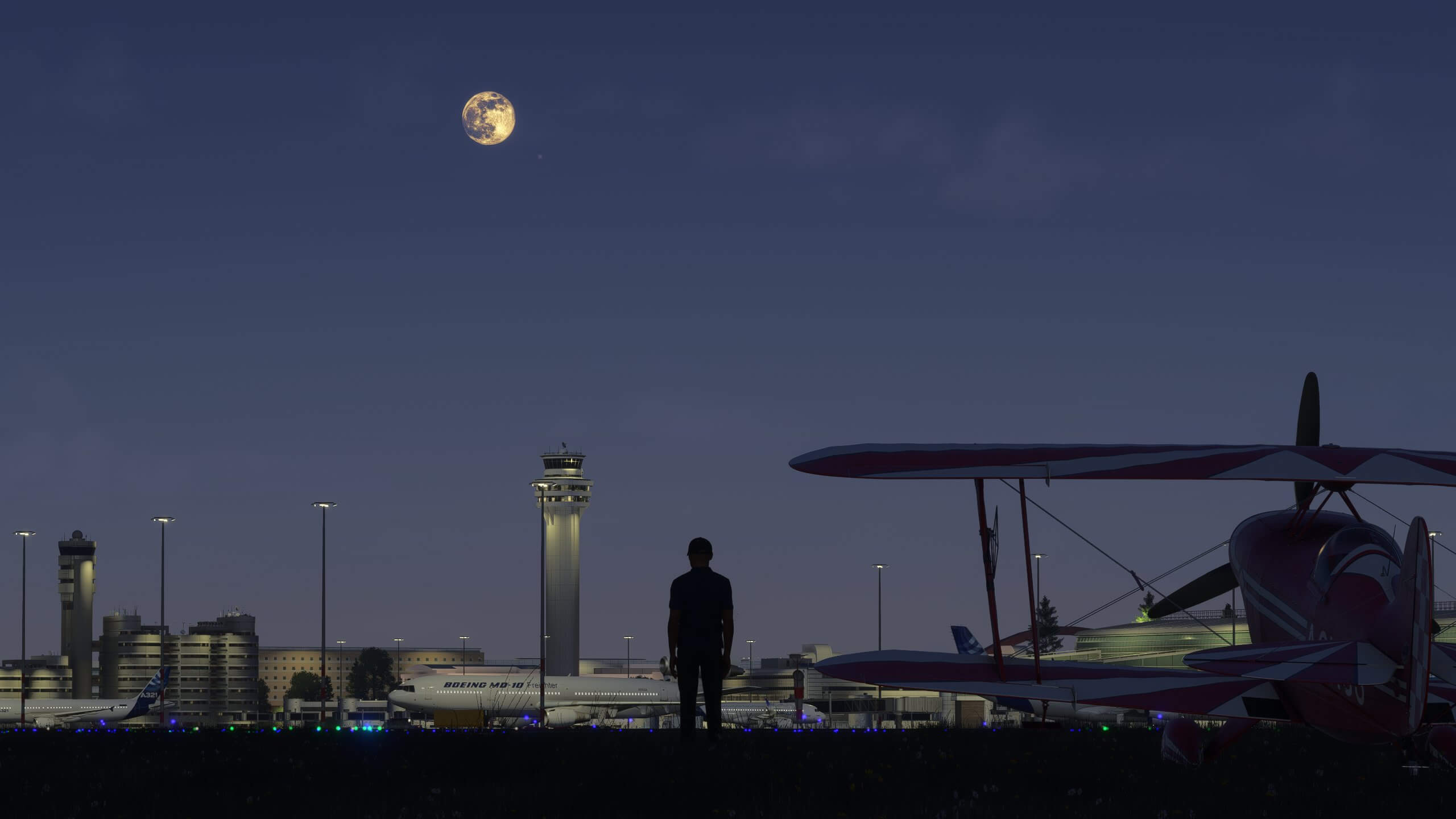 A pilot stands next to their propeller aircraft whilst looking at an international airport with the moon above